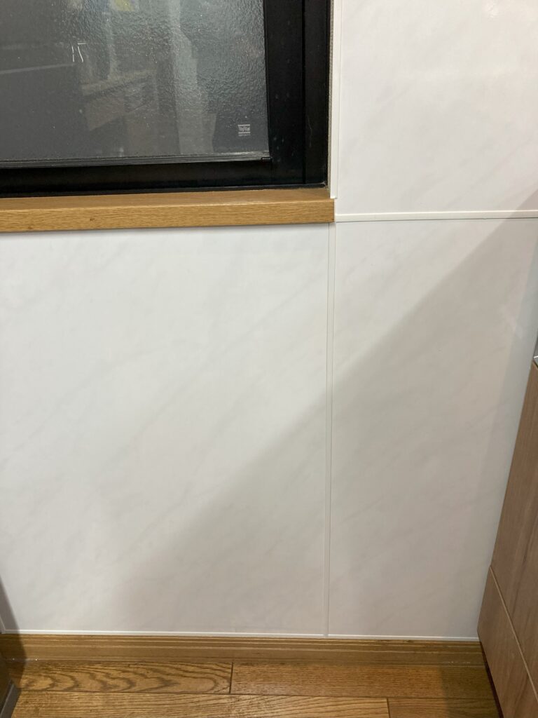 コンロ側壁窓下は汚れやすいとの事で、キッチンパネルを貼りました。