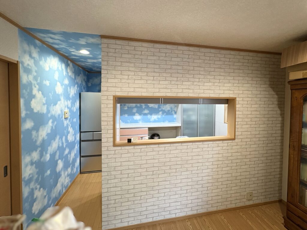 リビング側の壁には白のレンガ調クロスを採用。青空と雲柄のクロスが調和し、まるで絵本の世界を思わせるような、心が弾む空間に仕上がりました。